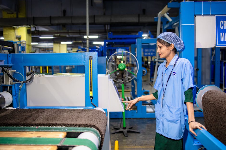 Female worker managing textile machinery in a modern factory setting, highlighting industrial operations.