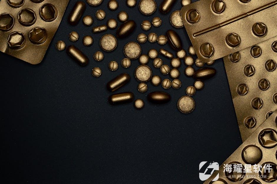 Close-up of gold blister packs and pills arranged on a black surface.