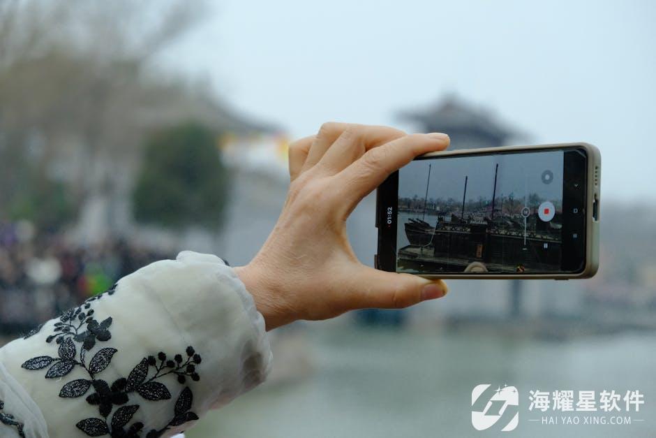 A hand holds a smartphone capturing a serene Chinese scene, blending technology and tradition.