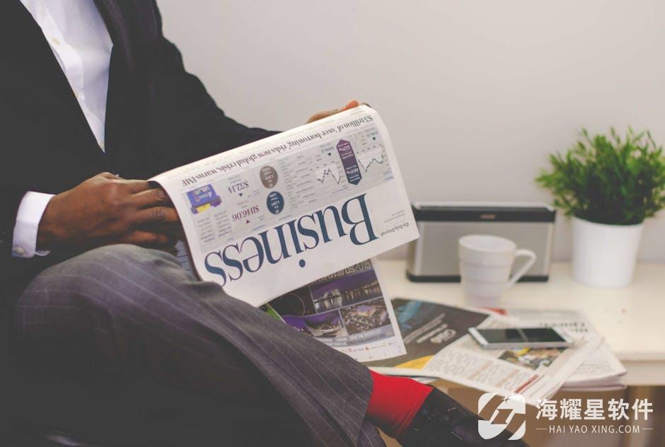 Businessman reading a financial newspaper at a desk, highlighting finance and commerce theme.