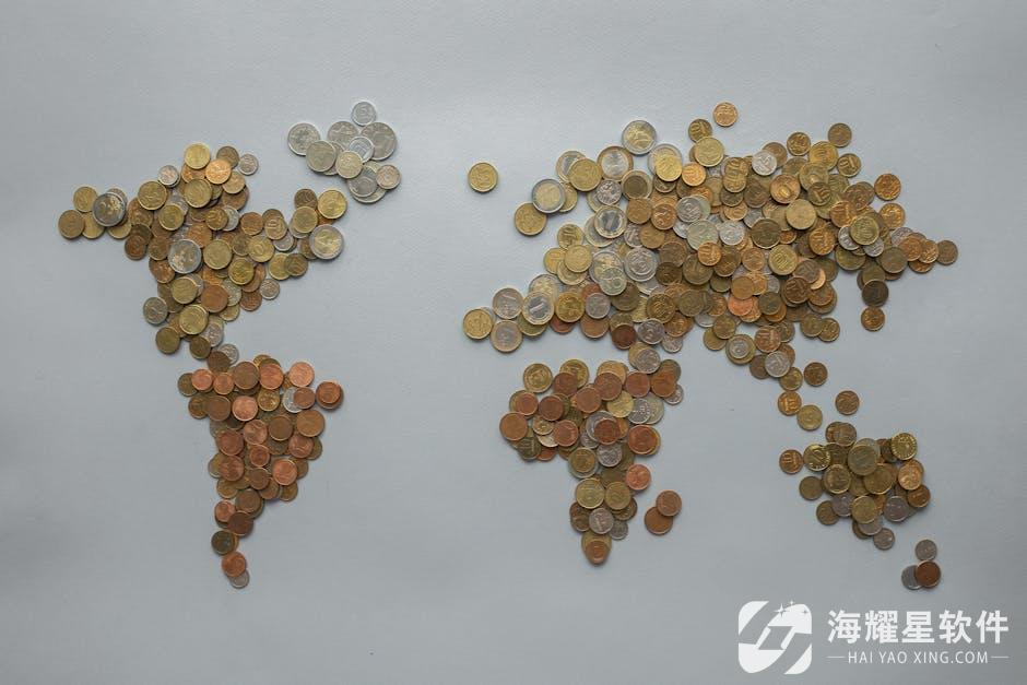 Creative world map made from assorted coins on a solid gray backdrop, symbolizing global finance.