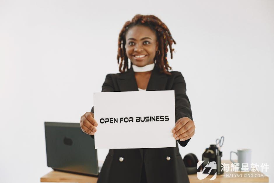 Smiling woman with dreadlocks holding an 'Open for Business' sign in an indoor studio setting.