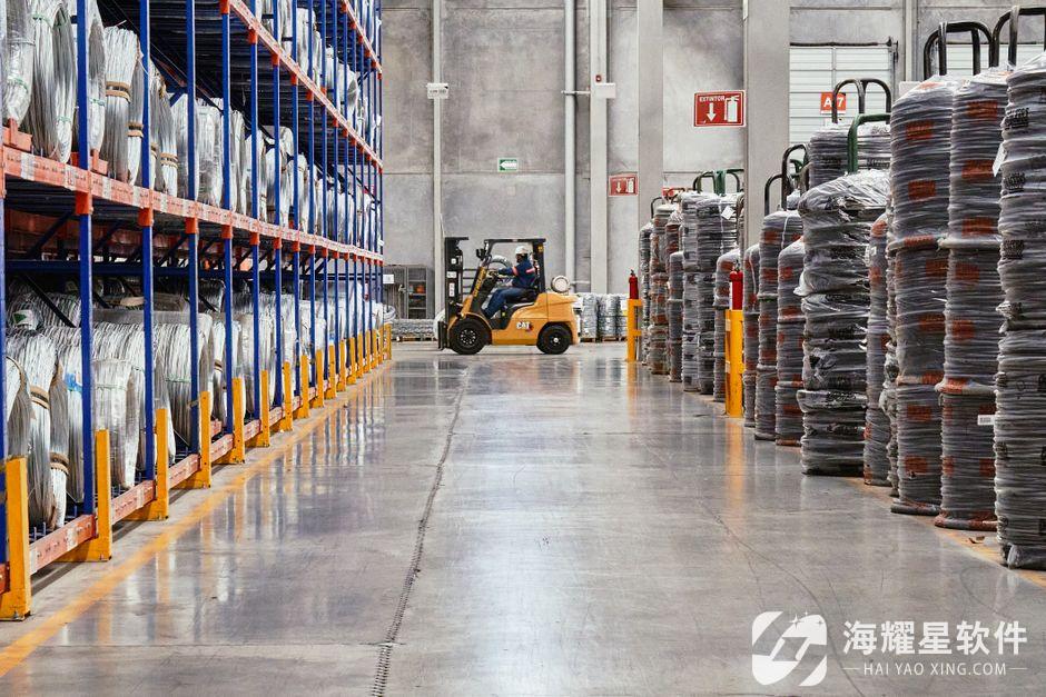 A forklift operates in an industrial warehouse with stacked goods. Efficient distribution setting.